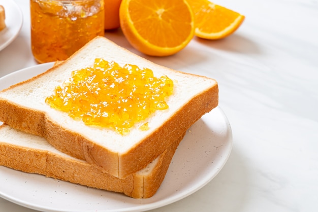 Kromki chleba z dżemem pomarańczowym