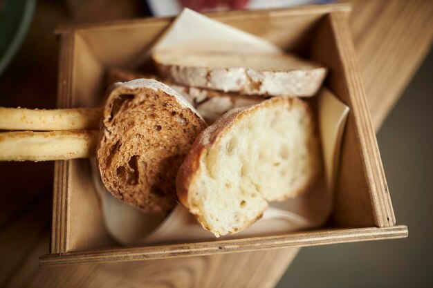 kromki świeżego chleba w drewnianym pudełku Żyto w plastrach z pestkami biały chleb leży w pudełku na chleb