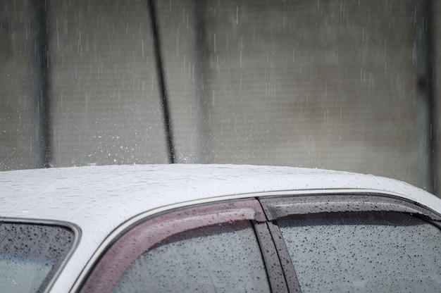 Krople deszczu na dachu samochodu w porze deszczowej