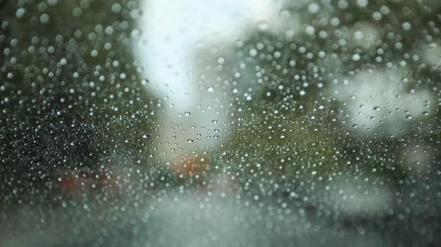 Krople deszczu na oknie z rozmytym tłem