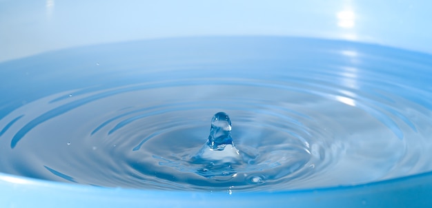 Krople wody kapią na niebieską wodę