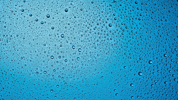 Krople wody na niebieskim przezroczystym tle