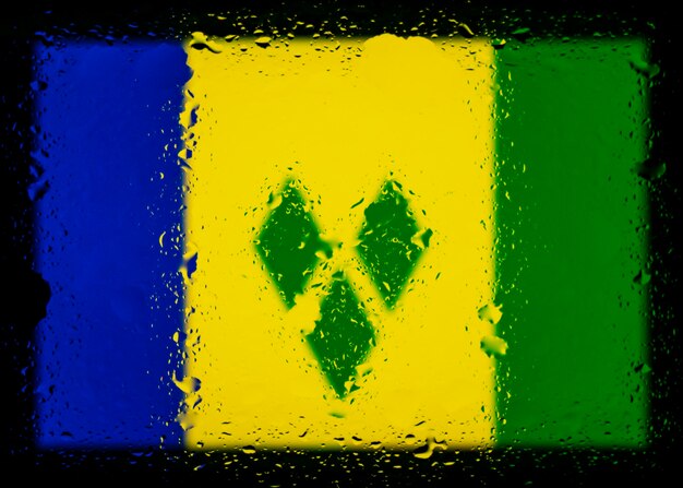 Krople wody na tle flagi Saint Vincent i granatów i Nevis Niewielka głębia ostrości Selektywna ostrość Stonowana