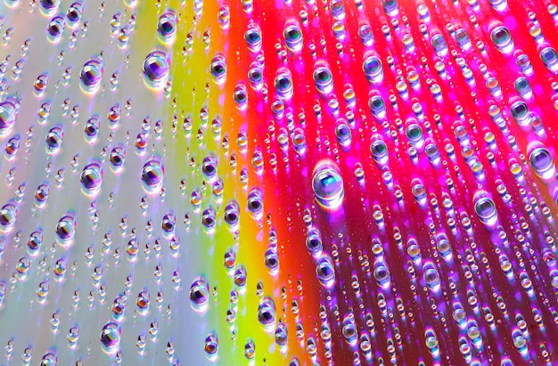 Krople wody o różnych rozmiarach na lustrzanej powierzchni zbliżenie makro-abstrakcyjne tło