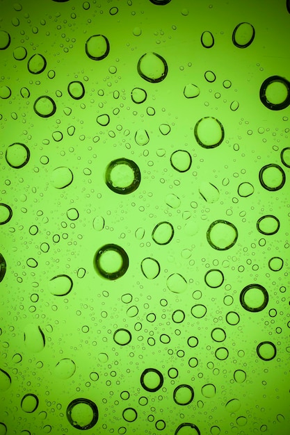 Zdjęcie krople wody tekstury na zielonym szkle.
