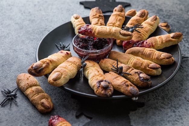 Krwawe ciasteczka paluszki na obchody Halloween, ciasteczka "Palce czarownic". Ciemne tło, jedzenie na Halloween