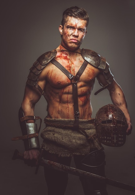 Krwawy gladiator w zbroi trzymający miecz. Na białym tle na szarym tle.