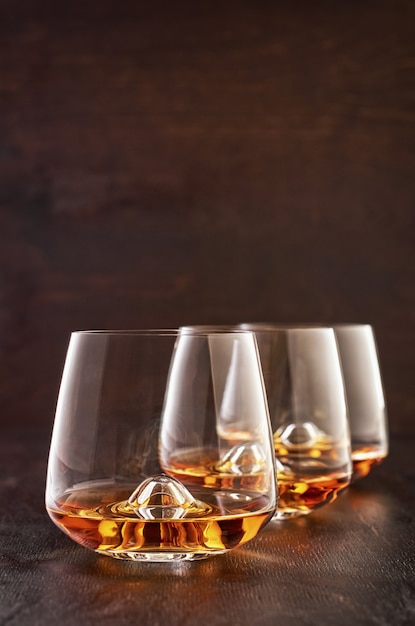 Krystaliczny szkło z whisky na drewnianym stole