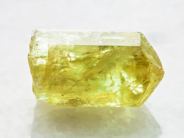 Kryształ żółtego kamienia apatytowego na białym