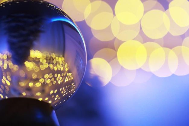Kryształowa Kula na podłodze z bokeh, światła z tyłu. Szklana kula z kolorowym światłem bokeh, koncepcja obchodów nowego roku.
