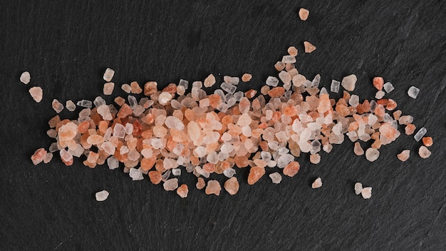 Zdjęcie kryształy różowej jadalnej soli himalajskiej na tle kamienia łupkowego