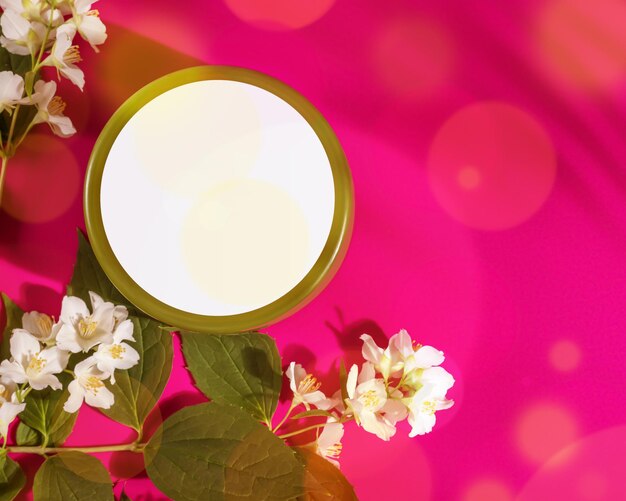 Krzemowy słoik do projektu Mock up Spa relaks tropikalny skład z naturalnym produktem kosmetycznym w okrągłym słoiku i kwiatami jasminu na różowym tle Letni krem nawilżający produkt kosmetyczny do pielęgnacji skóry