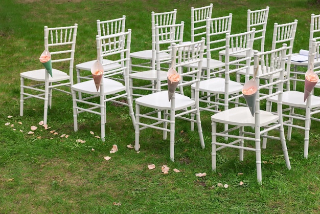Krzesła Chiavari na trawie Woreczki na krzesła z płatkami róż