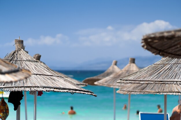 Krzesła I Parasol W Transparent Wakacje Tropikalny Palm Beach. Palmy na plaży i niebo. Letnie wakacje podróży koncepcja tło wakacje. Tropikalna sceneria. Góry. Pocztówka.