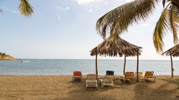 Krzesła na pokładzie i parasol na dachu na plaży