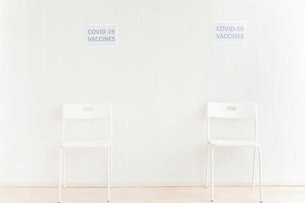 Krzesła ustawione w poczekalni, aby otrzymać szczepionkę przeciw krukowicom w przychodni lub szpitalu z białą ścianą