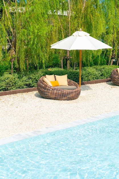 krzesło ogrodowe z poduszką i parasolem wokół basenu - koncepcja wakacji i wakacji