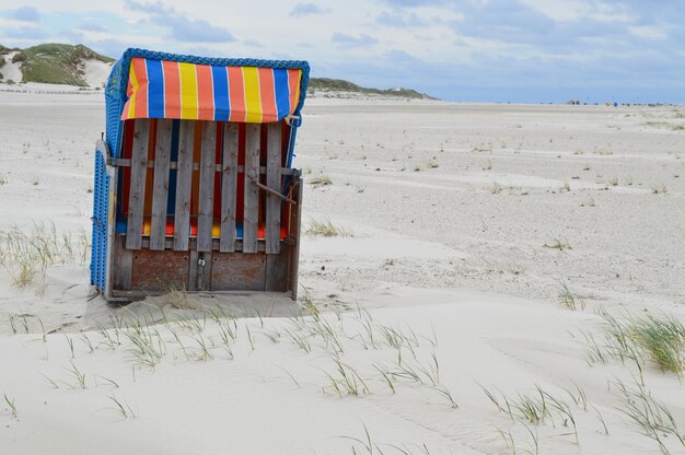 Krzesło z kapturem na plaży na tle nieba