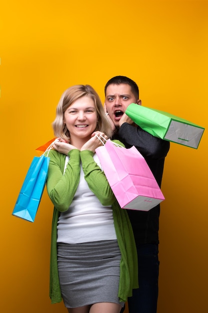 Krzyczący mężczyzna i kobieta z torbami na zakupy