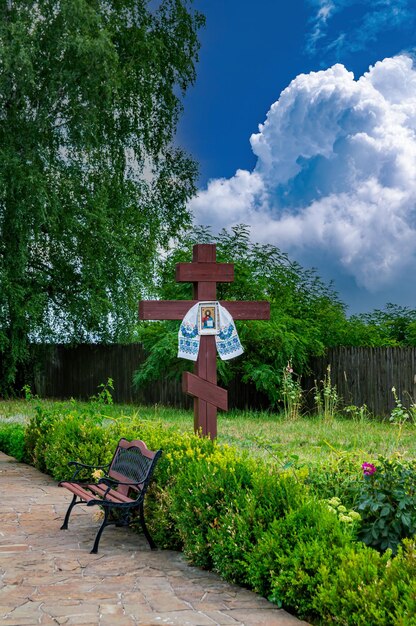Zdjęcie krzyż chrześcijański z ikoną na tle błękitnego nieba z chmurami