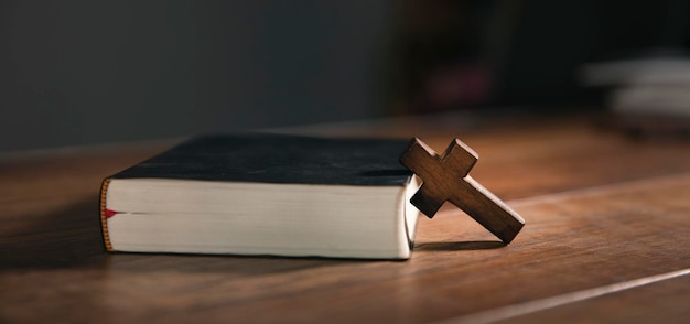 Krzyż na otwartym biblijnym drewnianym stole