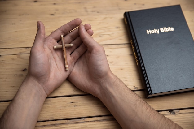 Krzyż ręka człowieka z Biblią