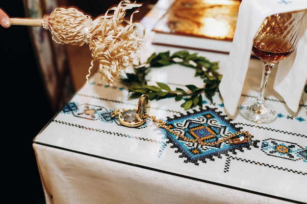 Zdjęcie ksiądz błogosławi złote obrączki ślubne leżące na stole w kościele