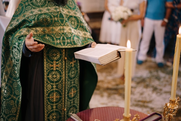 Zdjęcie ksiądz na weselu trzyma w ręku biblię