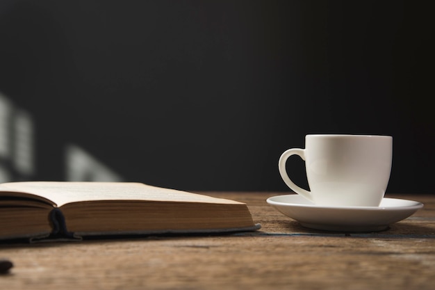 Książka i filiżanka kawy na drewnianym stole