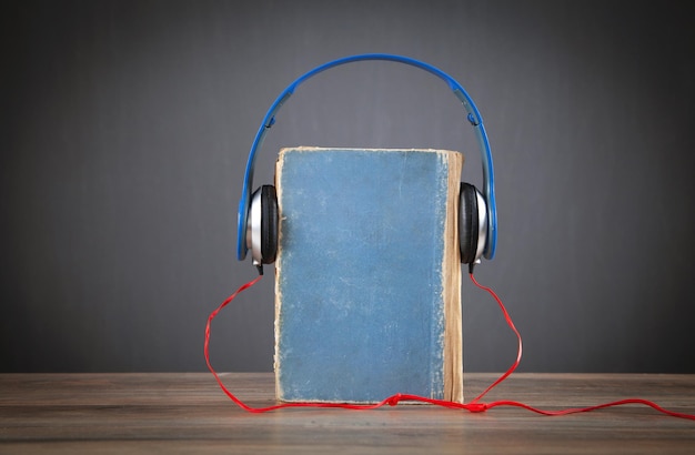 Zdjęcie książka i słuchawki na drewnianym stole audiobook