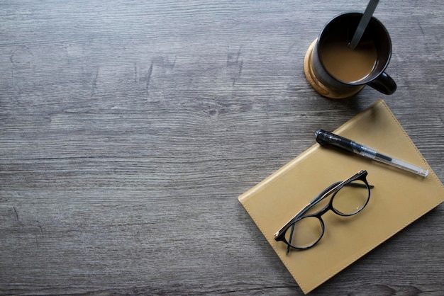 Książka Okulary Miejsce na długopis i kawę na drewnianym stole Kopiowanie miejsca