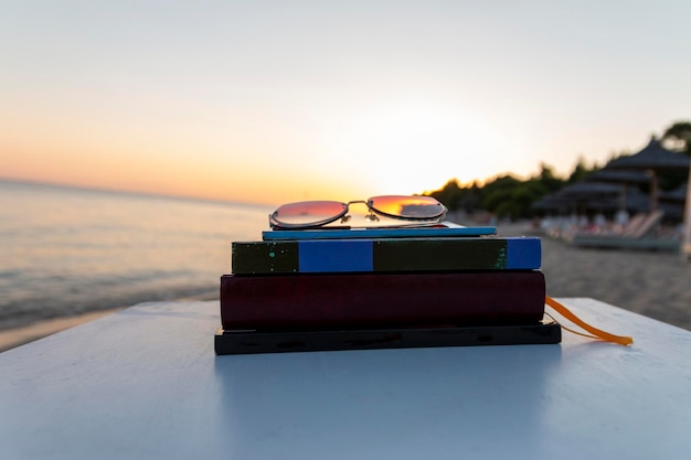 Zdjęcie książki na plaży przy morzu przy zachodzie słońca koncepcja szkoły