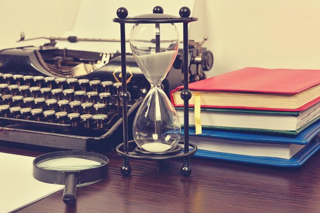 Książki z klepsydrą i zabytkowa maszyna do pisania