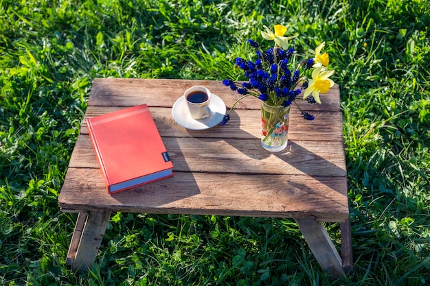książkowy kwiat i kawa na drewnie w przyrodzie