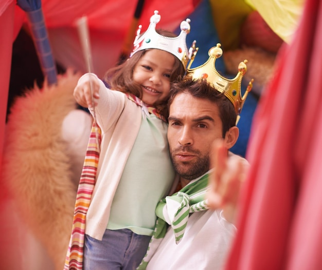 Księżniczka bawi się portretem taty i zabawą dla dzieci w forcie w sypialni z kostiumową dziewczyną i królem tatą razem Zamkowe szczęście i uśmiech z ojcem i dzieckiem w domu, podekscytowani i zadowoleni z gry