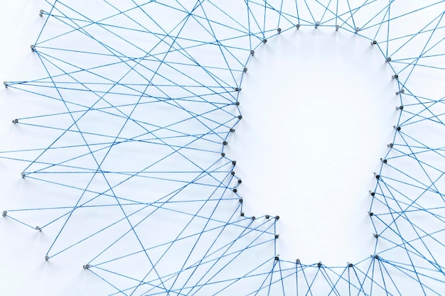 Zdjęcie kształt ludzkiej głowy wykonany z dużej siatki szpilek połączonych sznurkiem technologia komunikacji i koncepcja zdrowia psychicznego