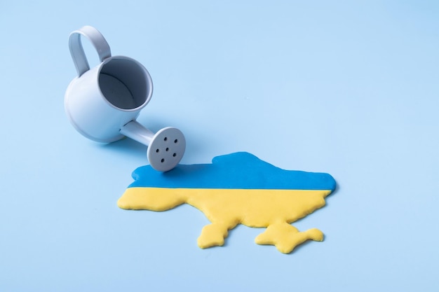 Kształt mapy Ukrainy w żółtych i niebieskich kolorach flagi narodowej i zraszacza Darowizny na inwestycje infuzyjne w koncepcji Ukrainy