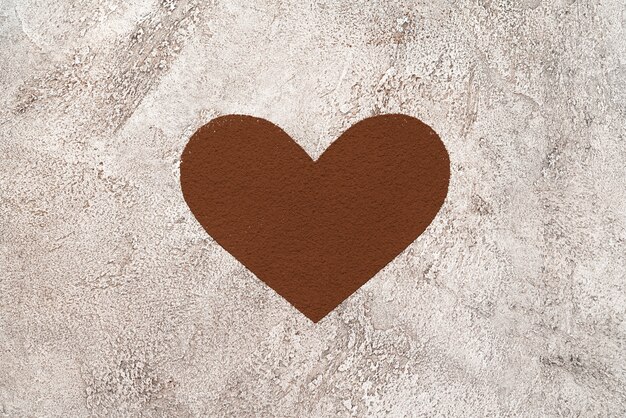 Kształt serca kakao w proszku na tle betonu