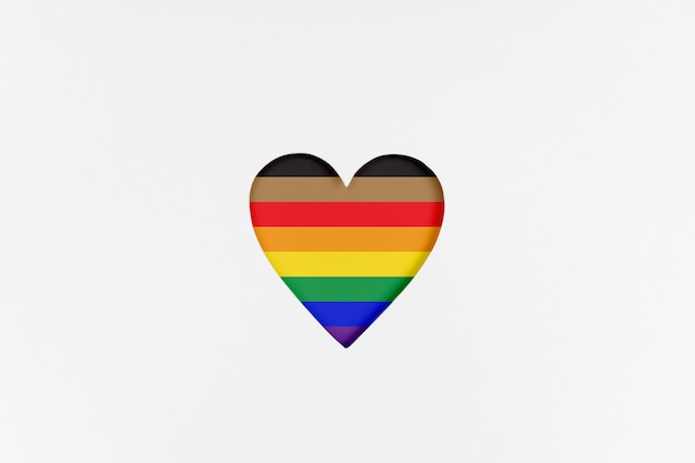 kształt serca z nową przeprojektowaną flagą dumy lgbtq na białym kartonie