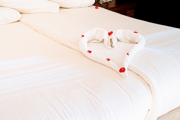 Kształt serca z ręczników na łóżku w pokoju hotelowym