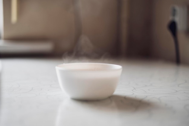 Kubek gorącego napoju na stole z aromatyczną parą