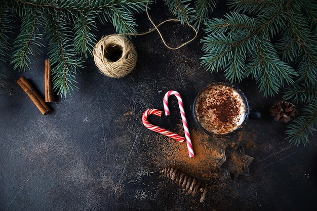 Kubek gorącej czekolady lub kakao z kremem waniliowym świąteczna dekoracja domu na ciemnym kamiennym tle