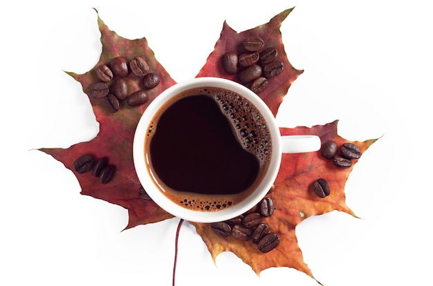 Kubek gorącej kawy i jesienny liść klonu na białym tle, widok z góry