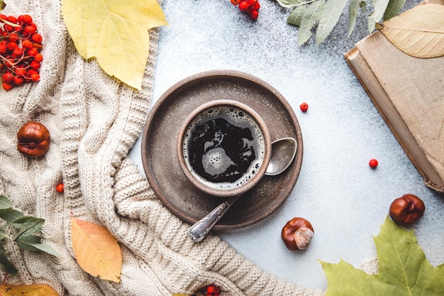 Kubek gorącej kawy koc i jesienne liście na jesiennym tle Vintage tonujący jesienny relaks koncepcja