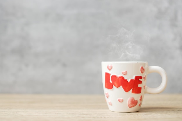 Kubek kawy na tle stół z drewna rano, puste miejsce na tekst. Międzynarodowy dzień kawy, szczęśliwy Walentynki i koncepcja codziennej rutyny