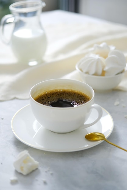 Zdjęcie kubek kawy z białym jasnym wnętrzem kubek kawy na stole z deserami