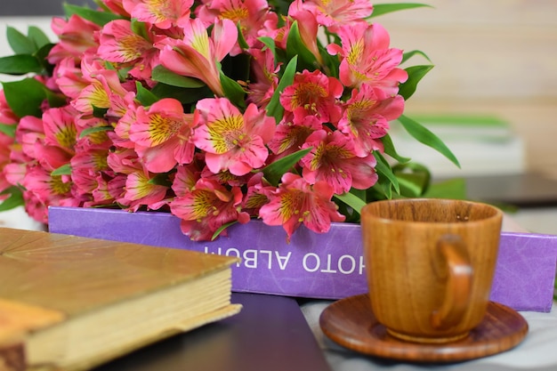 Zdjęcie kubek z kwiatami herbaty i album ze zdjęciami poranna kawa z kwiatami