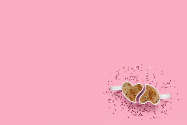 Kubki z kawą i konfetti na różowym tle. Widok z góry koncepcji walentynek z miejsca na kopię