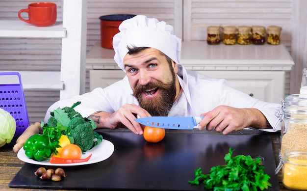 Kucharz przygotowujący smaczną świeżą sałatkę warzywną kucharz z ostrymi nożami cięcie pomidorów dieta zdrowe jedzenie