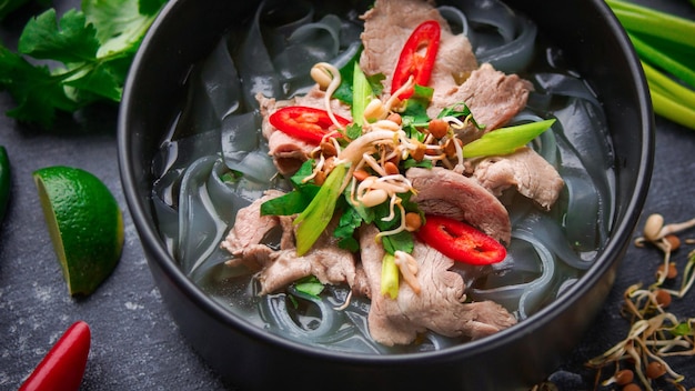 Kuchnia azjatycka, wietnamska zupa pho bo w czarnym talerzu na ciemnym